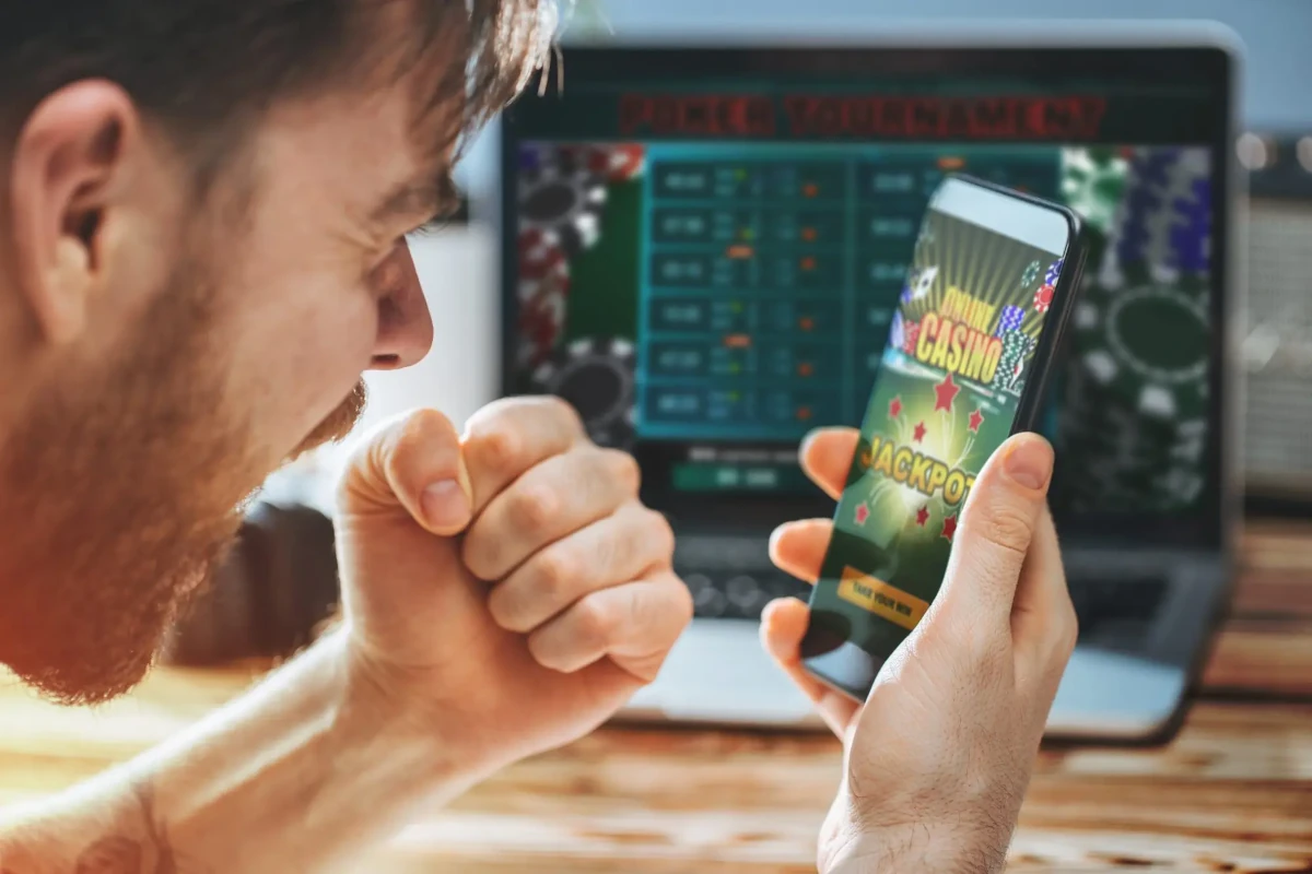 a man looking at this phone winning in online casino game